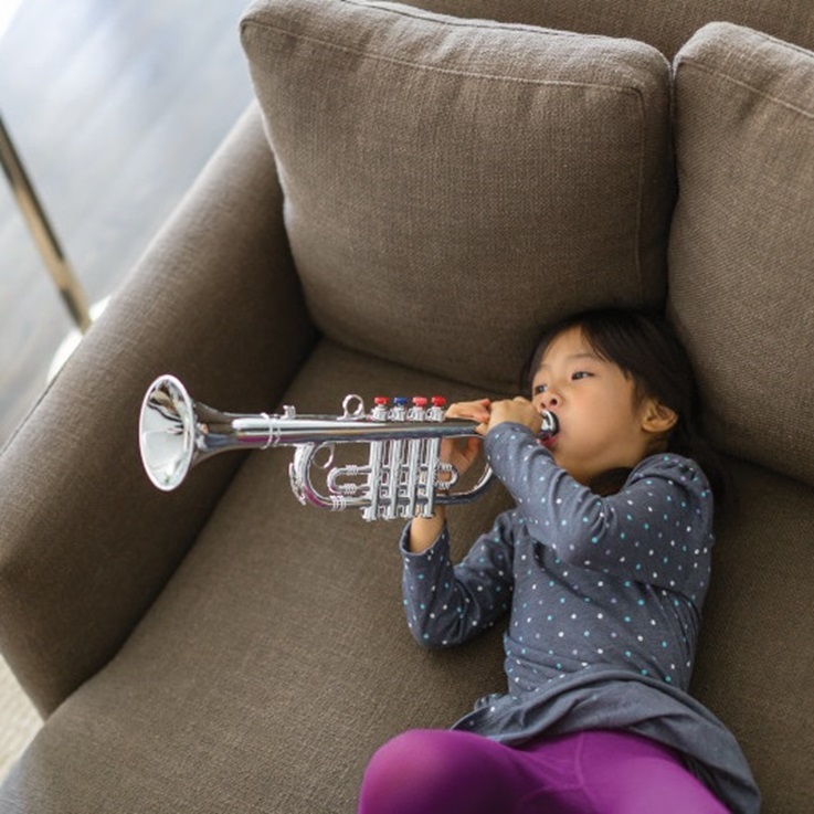 Girl on sofa playing instrument